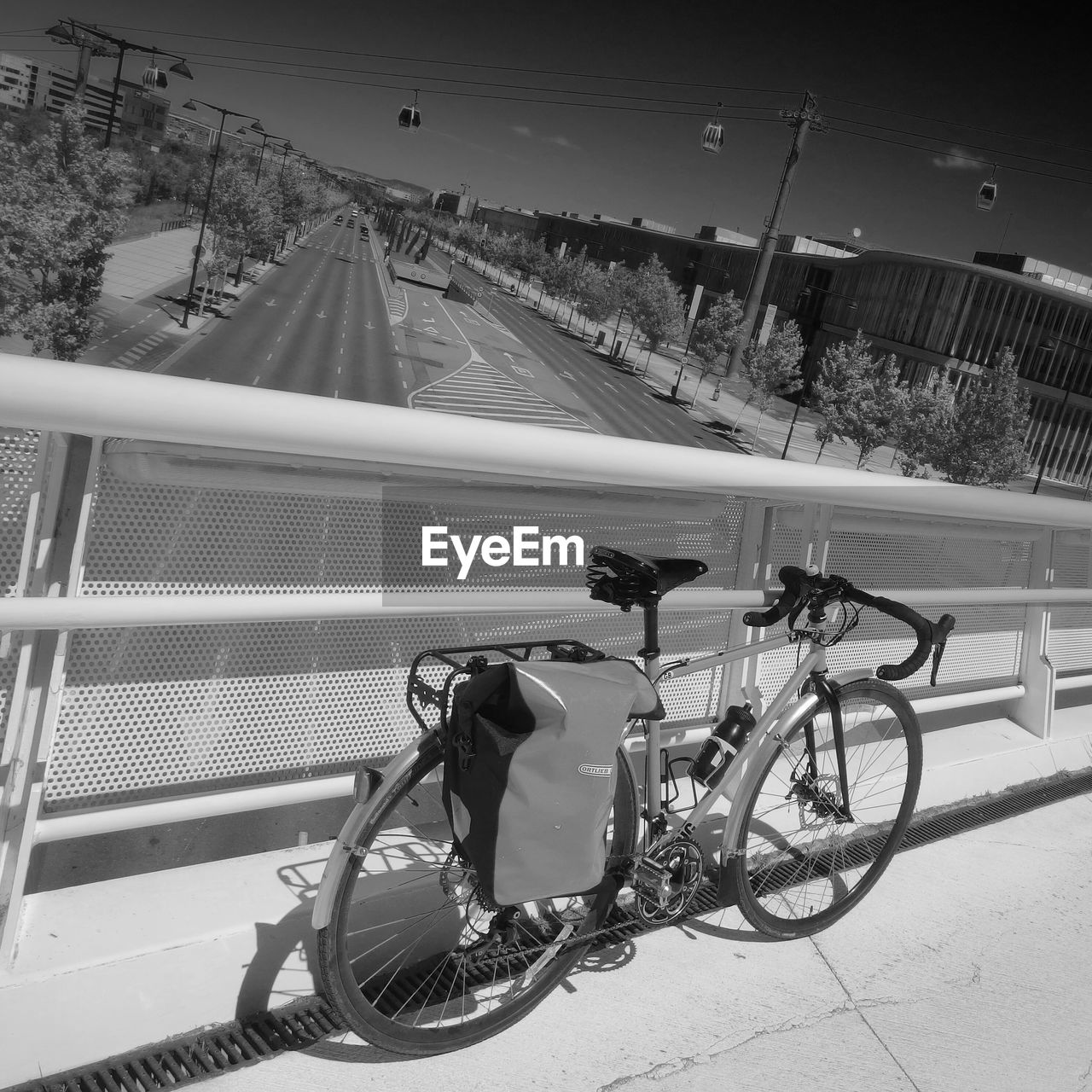 High angle view of bicycle leaning on railing at bridge over highway