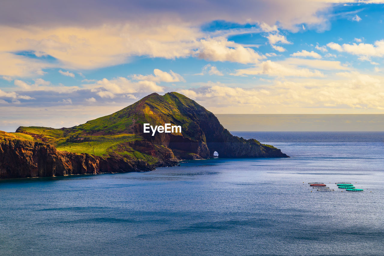 scenic view of sea and mountains against sky during sunset