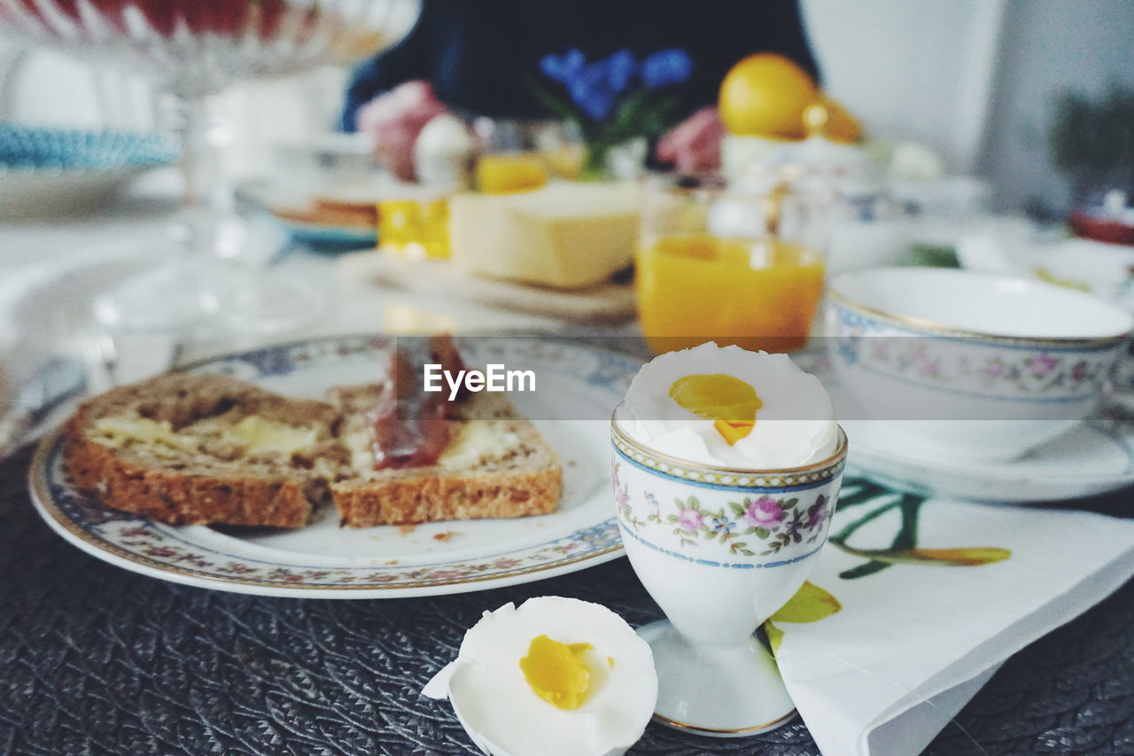 Close-up of boiled egg and sandwich on place mat at dining table