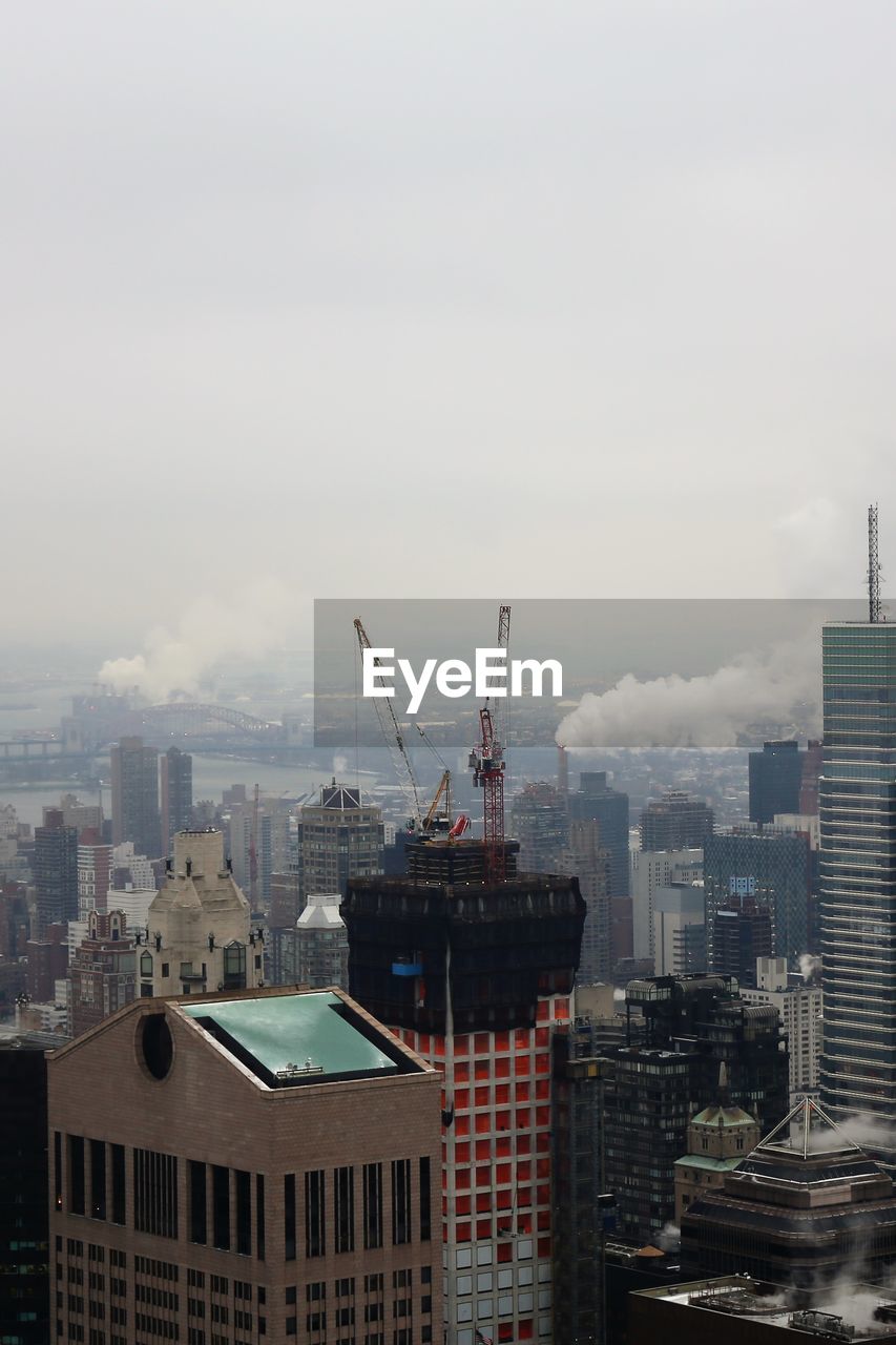 Aerial view of buildings in city against sky