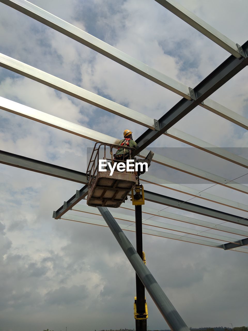 Low angle view of man working against sky