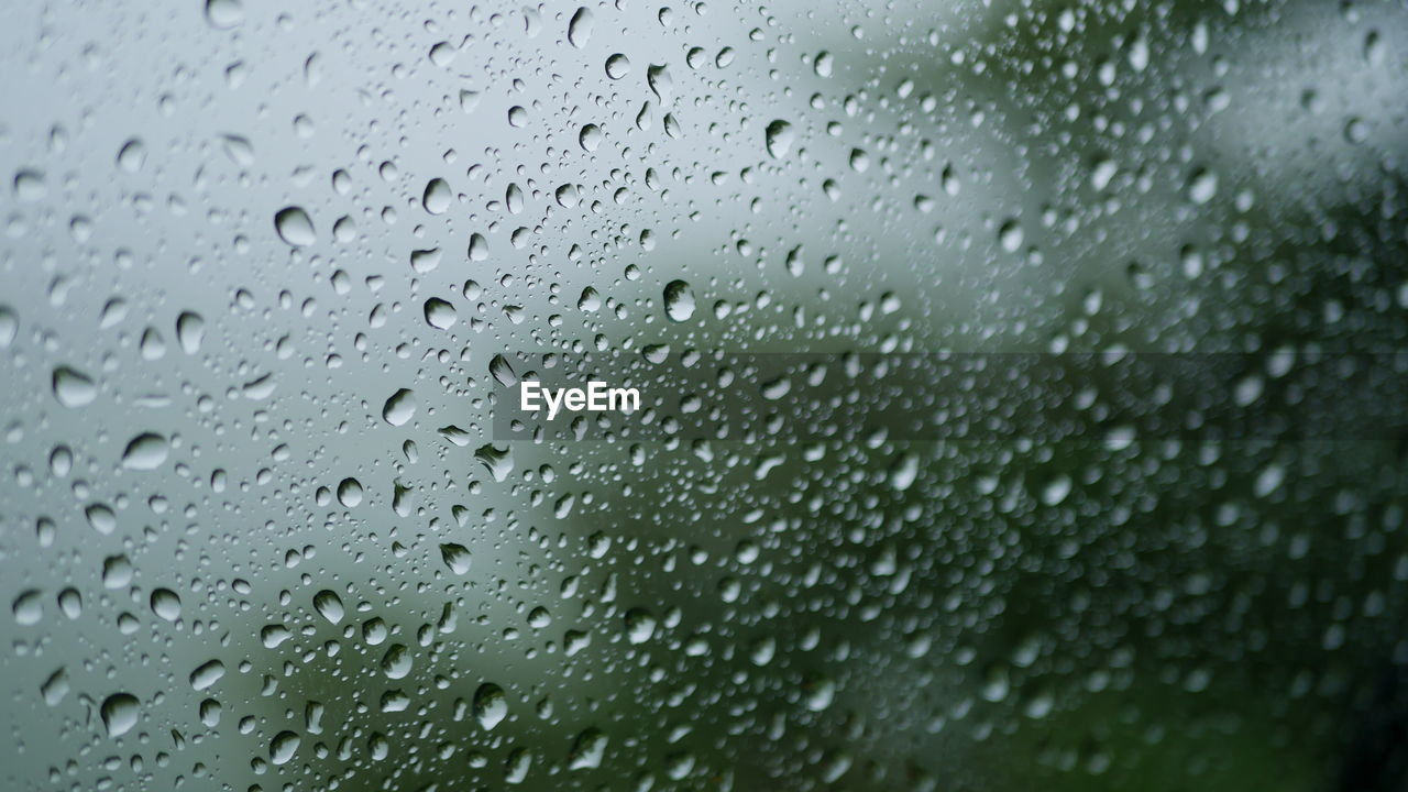 Full frame shot of wet glass window during rainy season