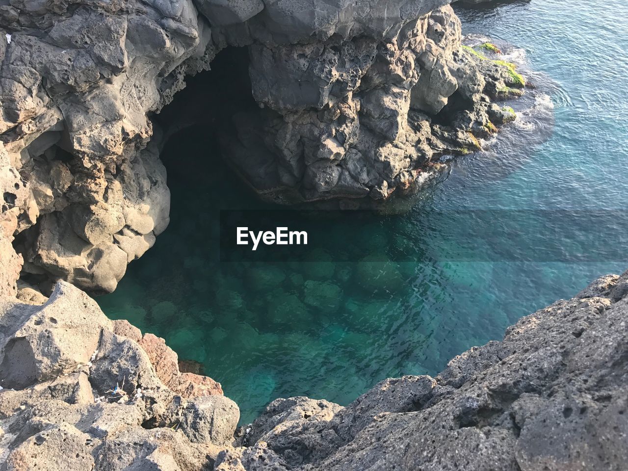 HIGH ANGLE VIEW OF ROCKS ON SEA SHORE