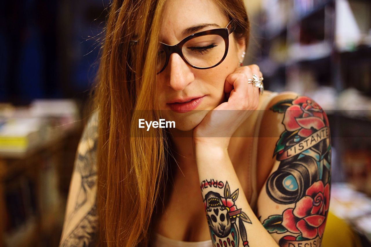 Close-up of woman with tattoo sitting at home