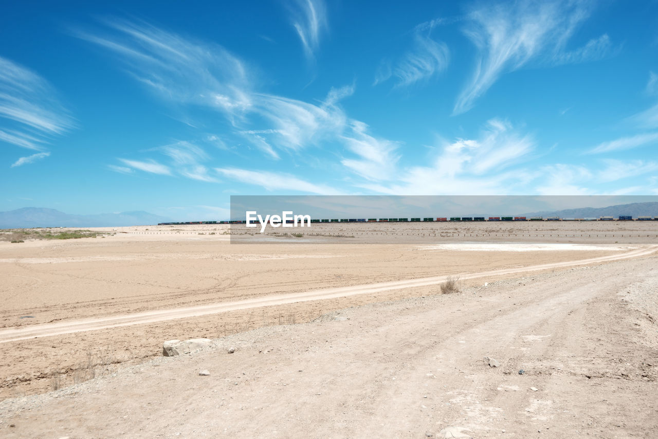 Scenic view of desert against blue sky