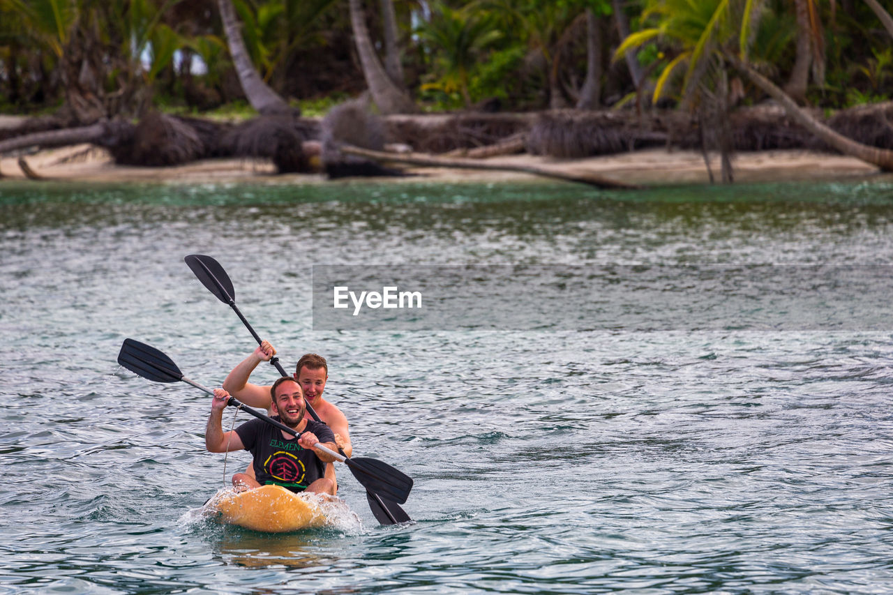 Friends rowing on river