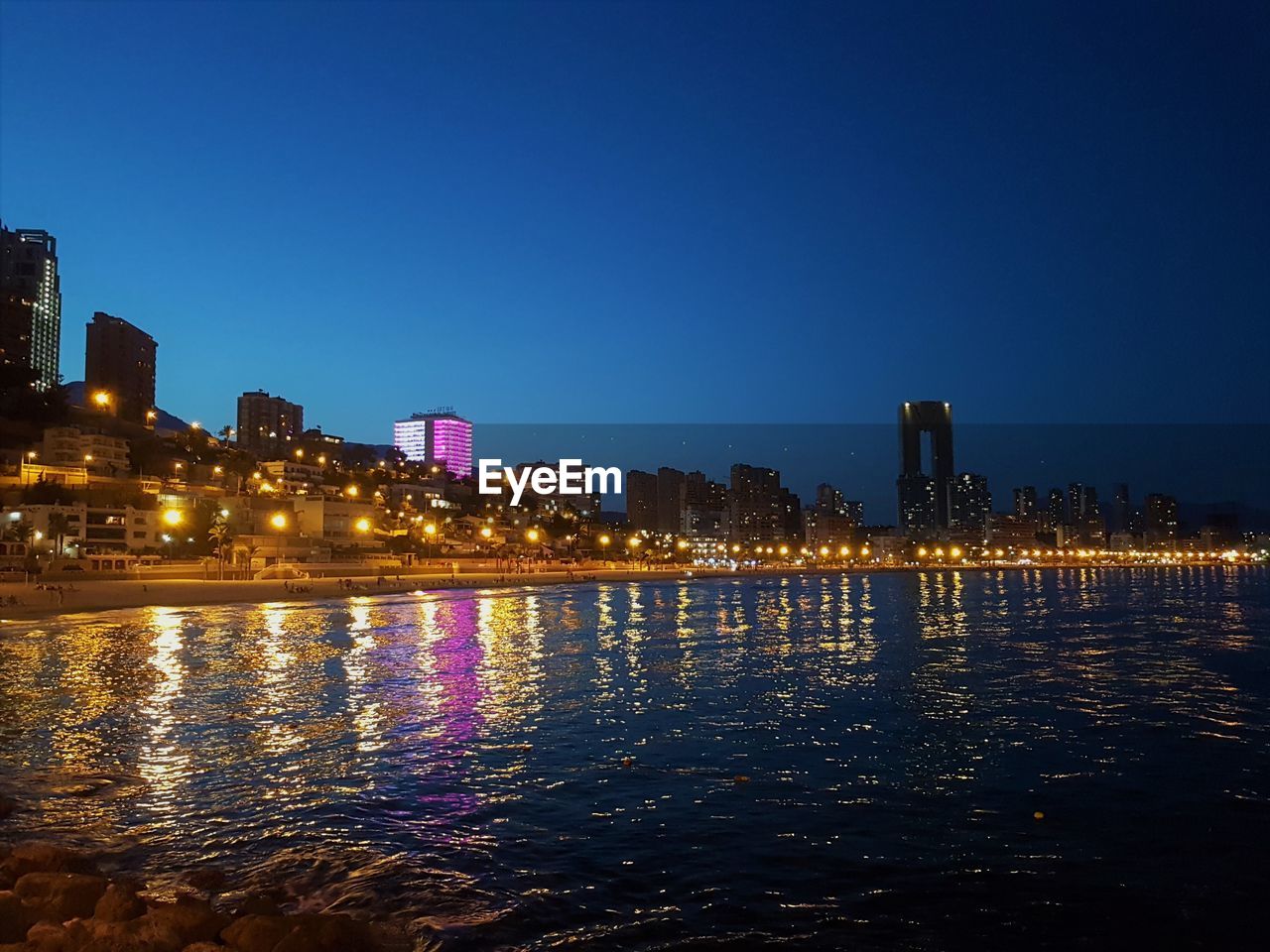 ILLUMINATED BUILDINGS IN CITY AT NIGHT