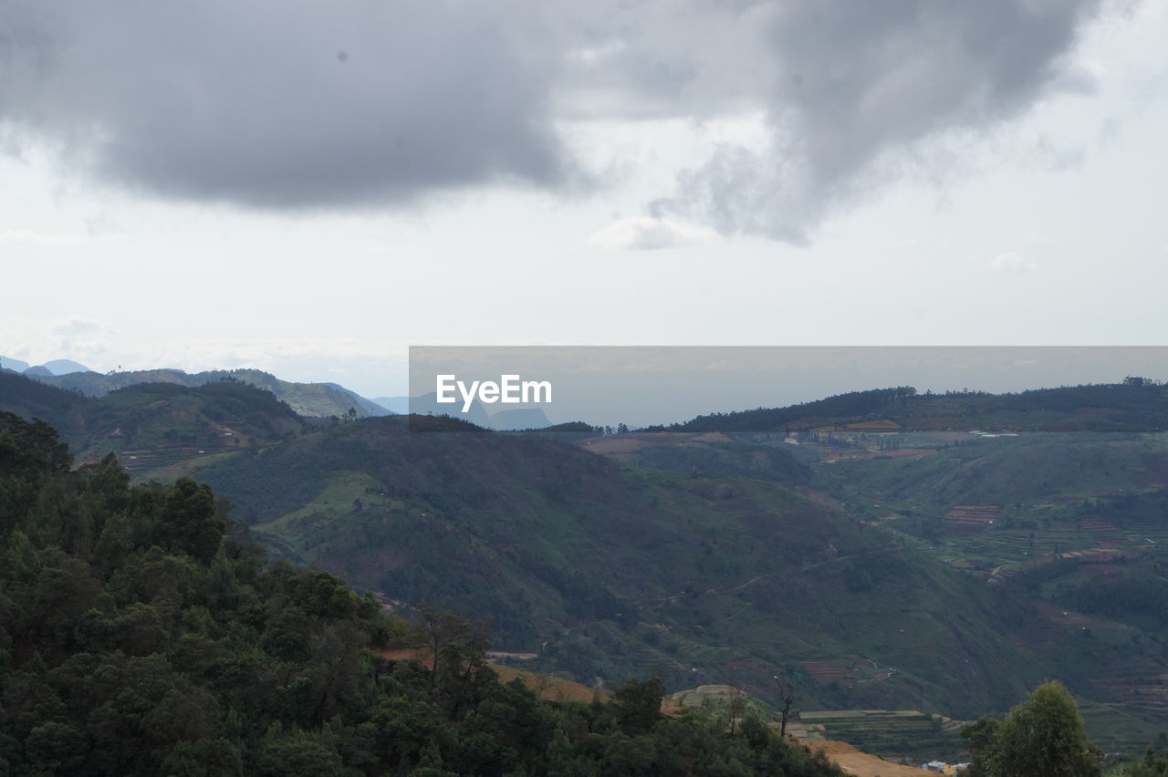 SCENIC VIEW OF MOUNTAINS AGAINST CLOUDY SKY