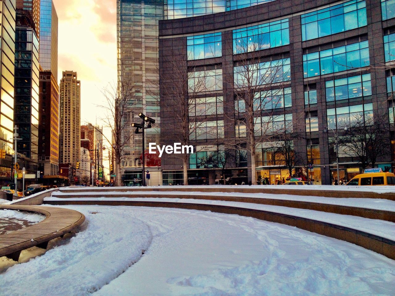 Empty snowed road along buildings