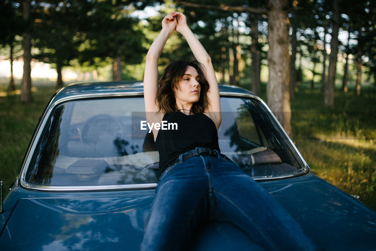 Portrait of a hipster woman sitting on the car