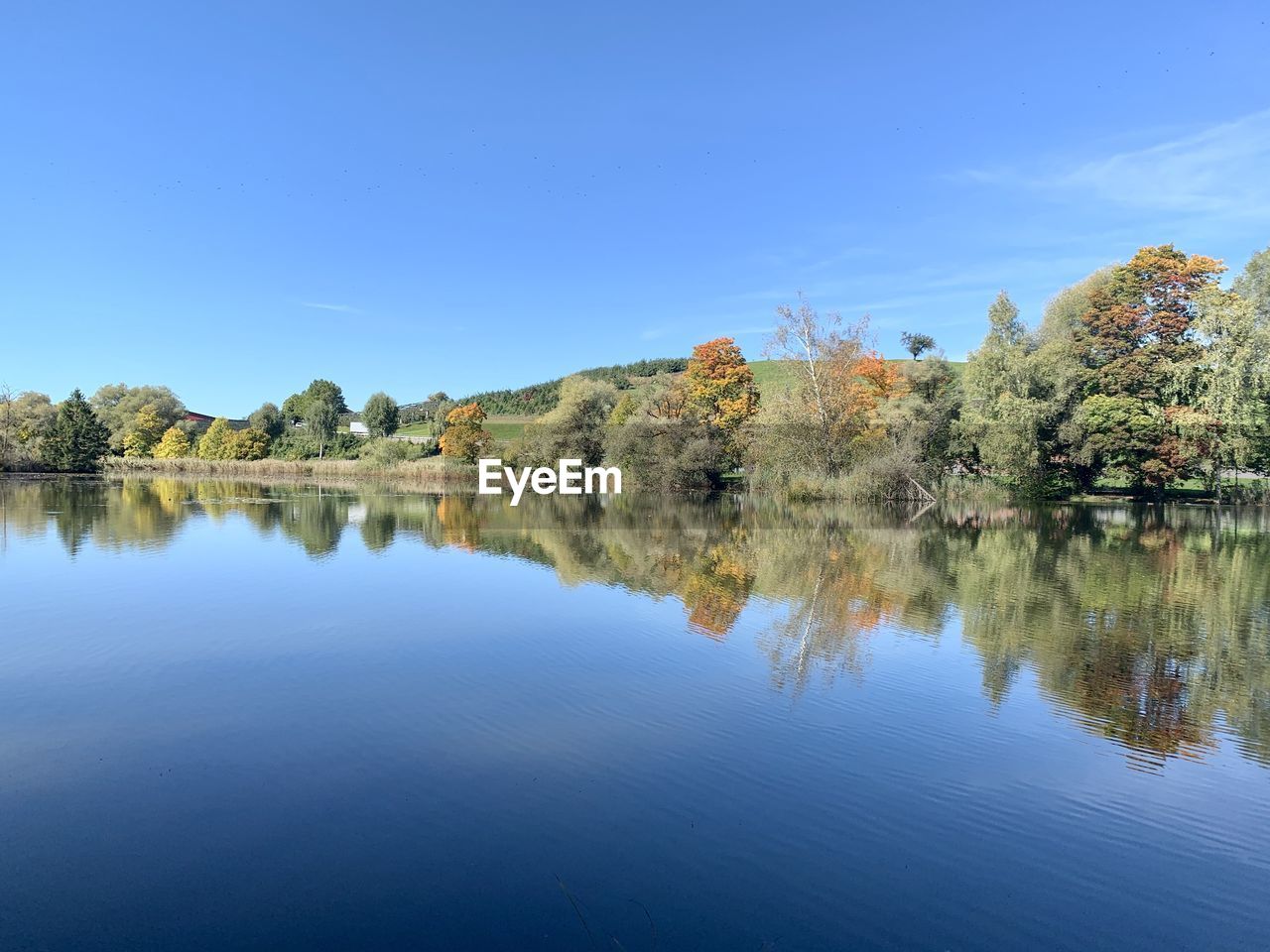 Scenic view of lake against clear blue sky