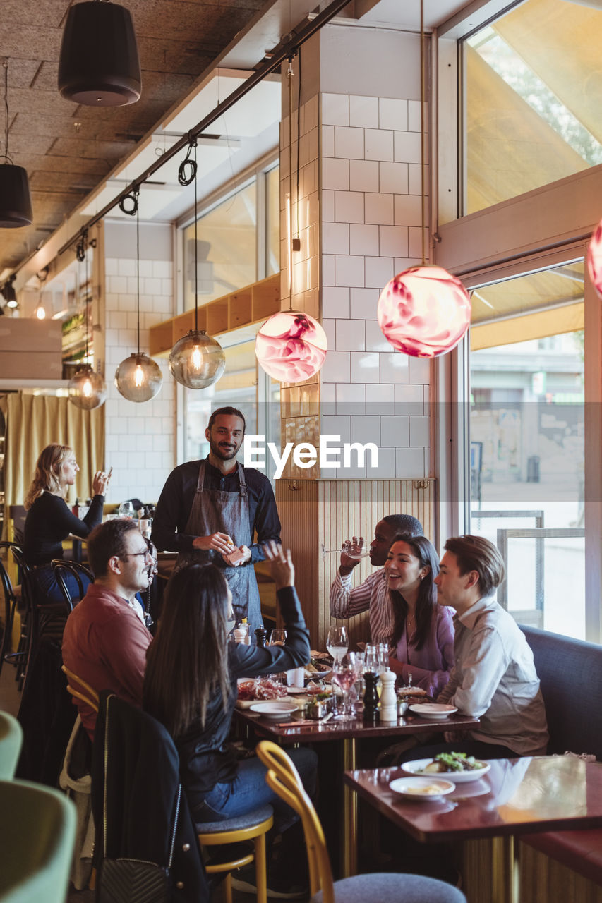 Male and female friends having dinner at restaurant afterwork