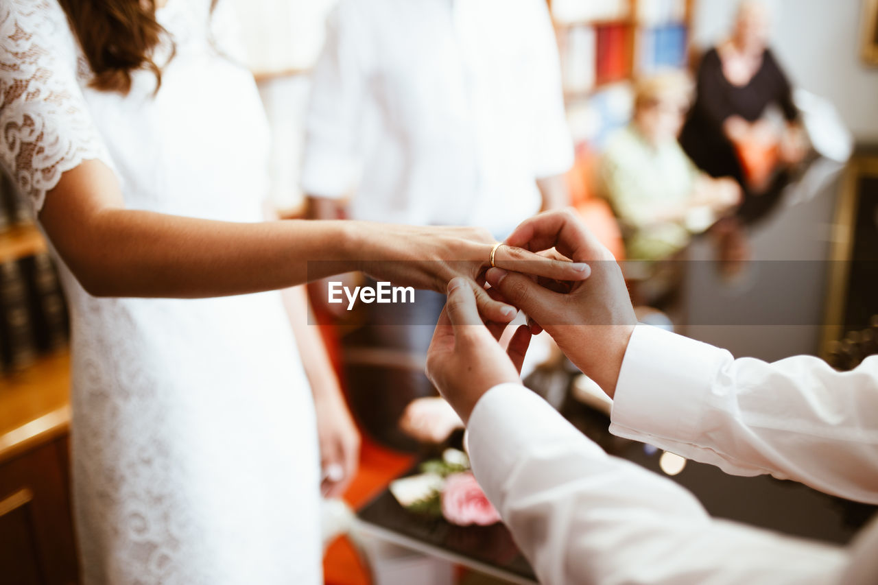 Man putting wedding ring on woman finger. exchange wedding rings. happy groom and bride. 