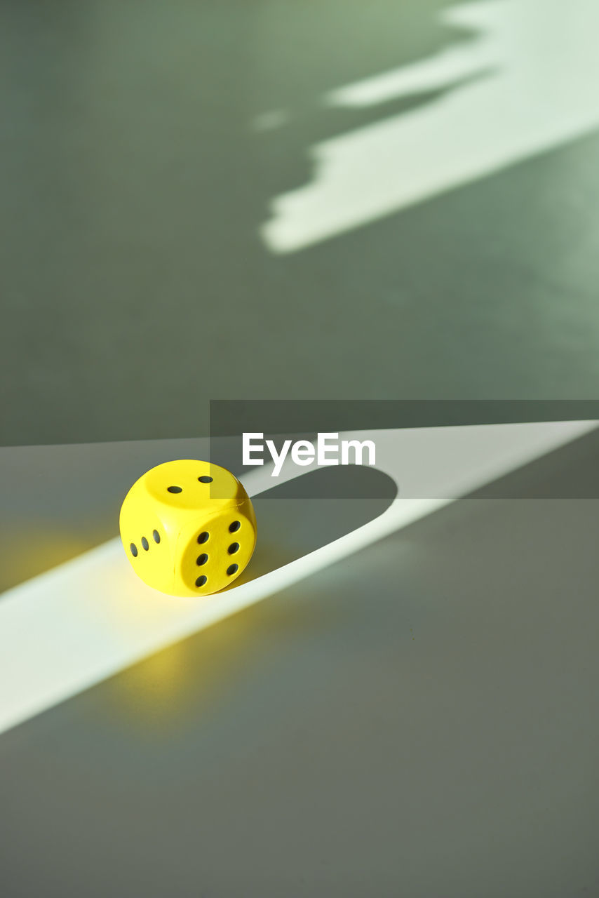 High angle view of yellow dice on table