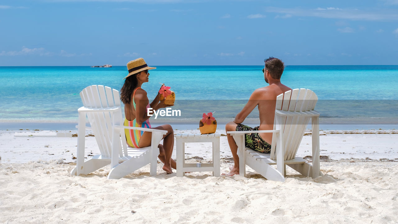 rear view of woman sitting on beach