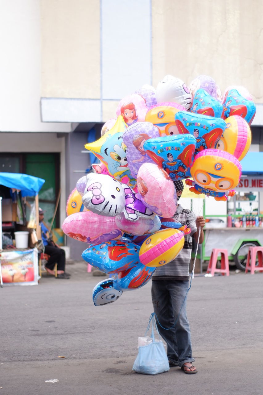Boy holding colorful balloons for sale