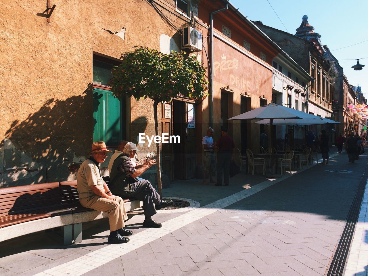 People on alley by buildings in city