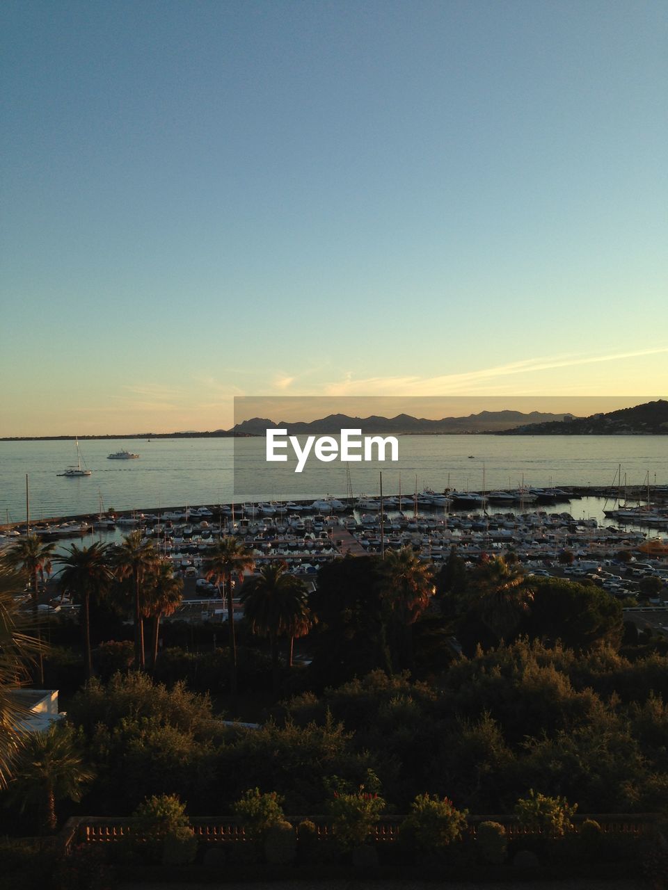 Boats at sea against sky during sunset