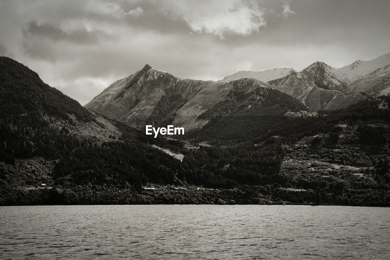 Scenic view of lake by mountains against sky