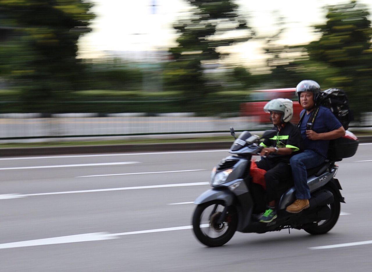 BLURRED IMAGE OF WOMAN RIDING MOTORCYCLE