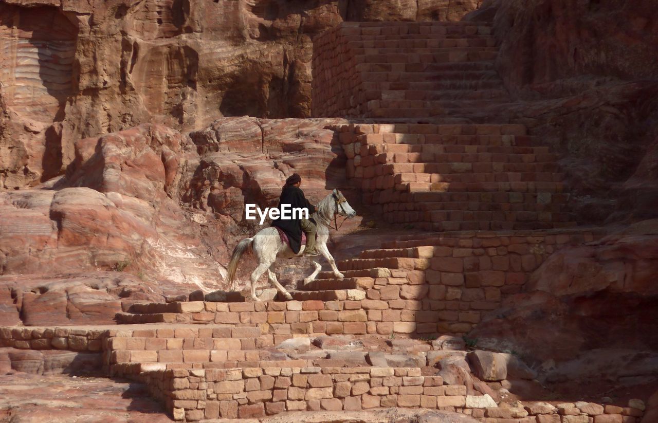 Man riding on horse at petra steps