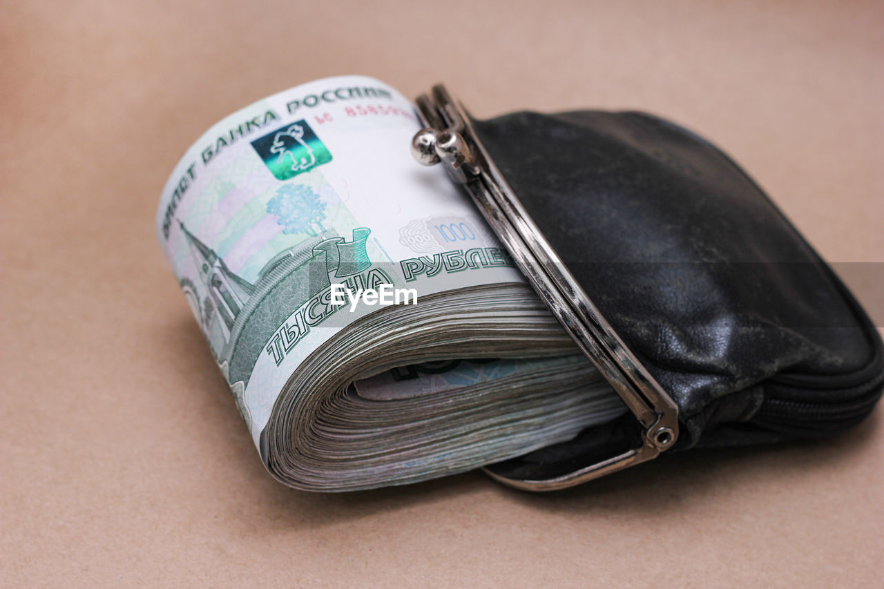 high angle view of wallet with paper currencies on table