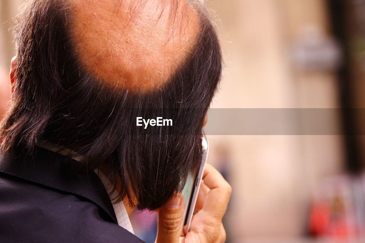 Rear view of man using smart phone