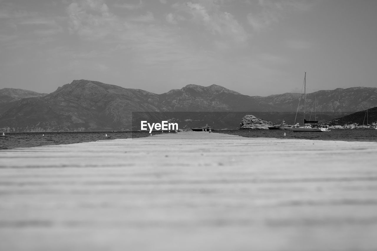 Scenic view of sea and mountains against sky