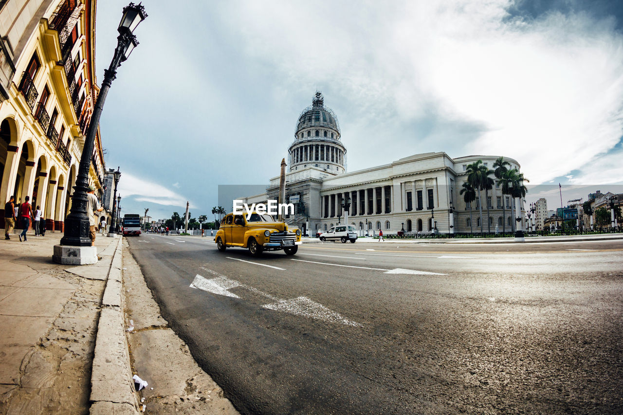 VIEW OF CITY STREET AGAINST CLOUDY SKY