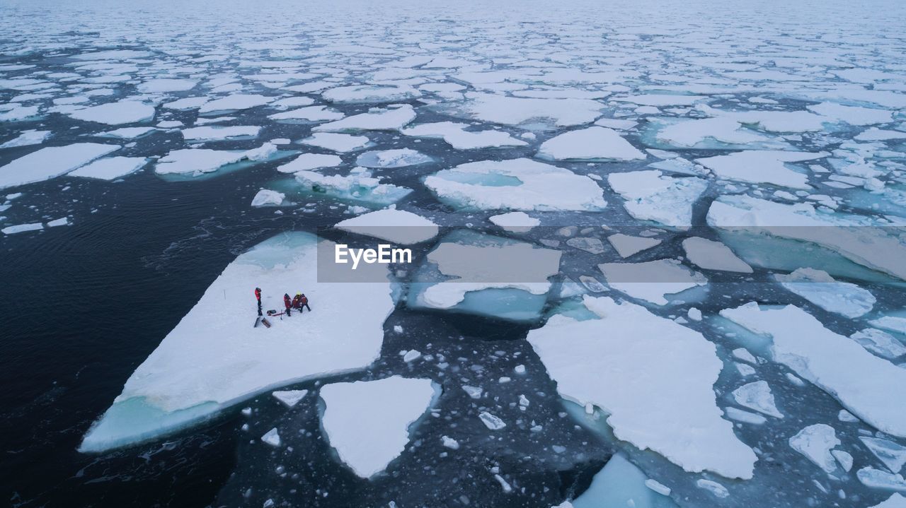 HIGH ANGLE VIEW OF FROZEN WATER ON SNOW