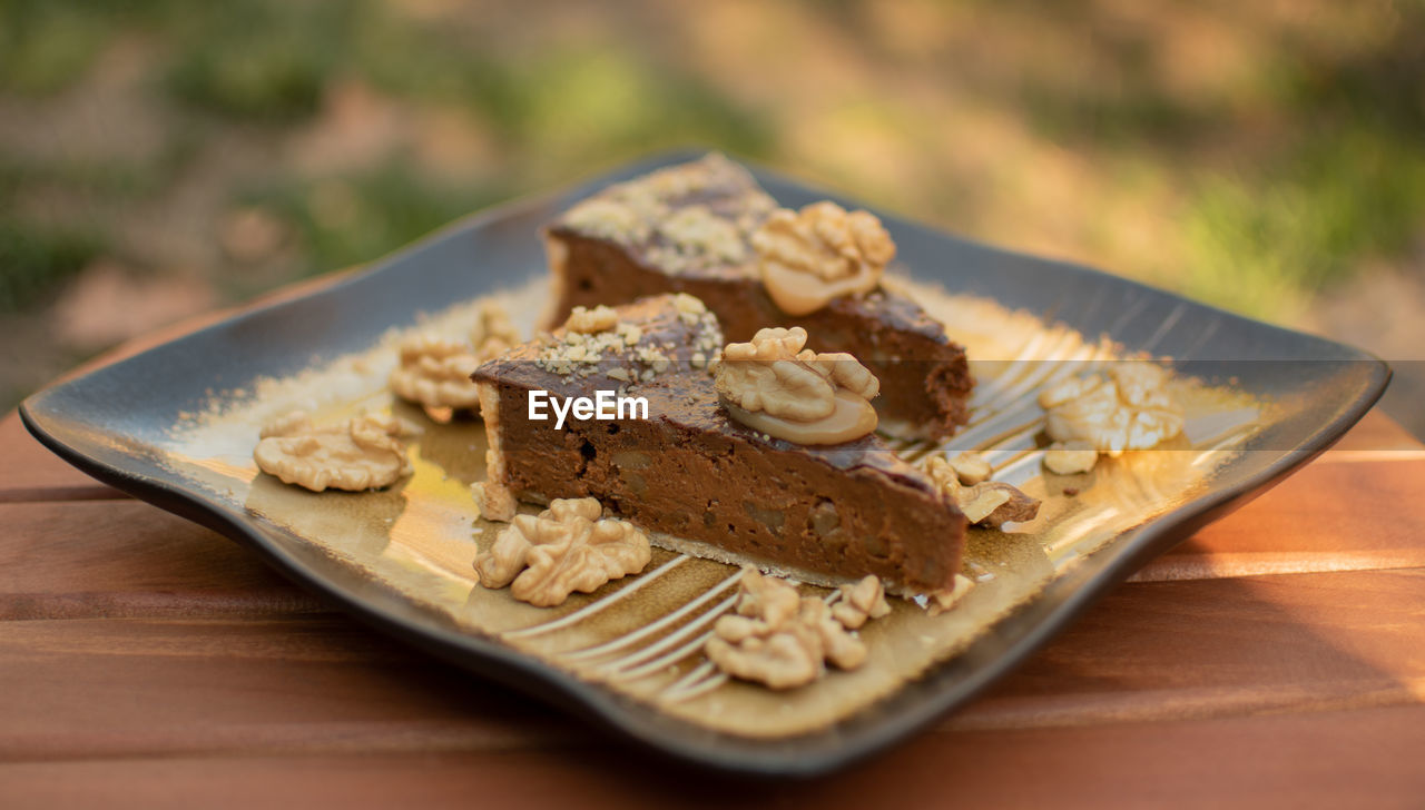 Two pieces of pecan pie on an elegant plate.