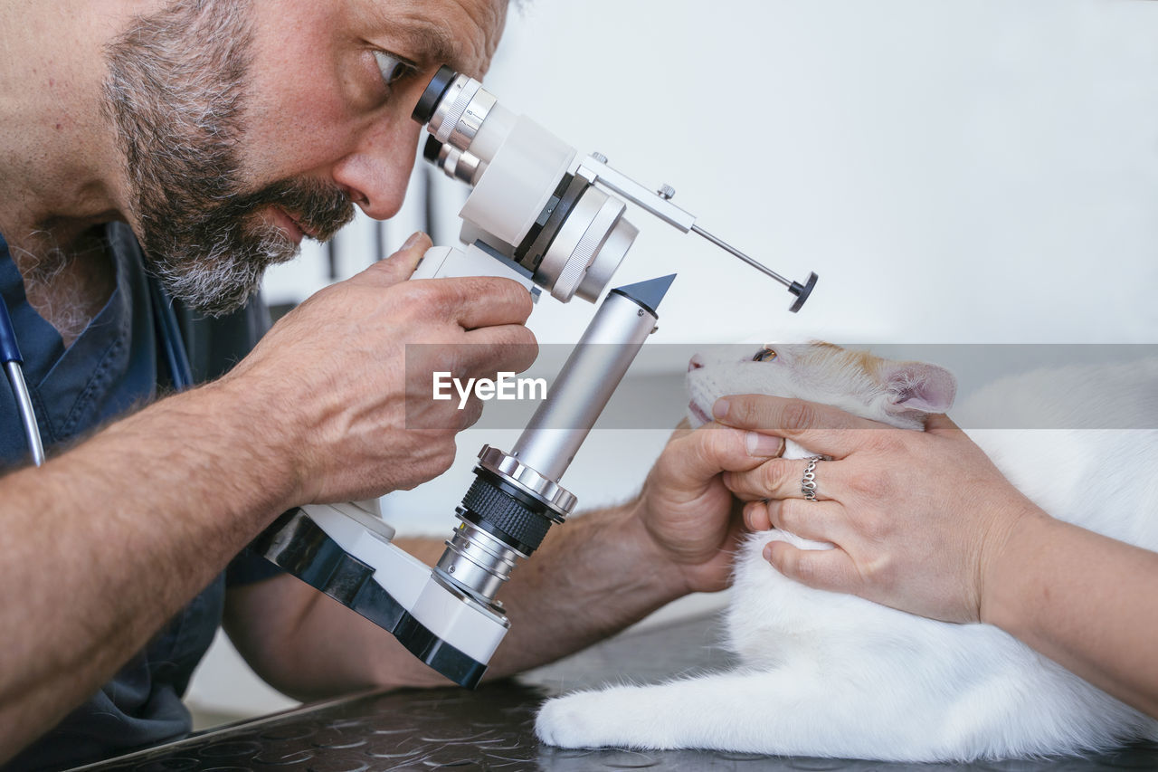 LOW ANGLE VIEW OF MAN WORKING ON CAMERA