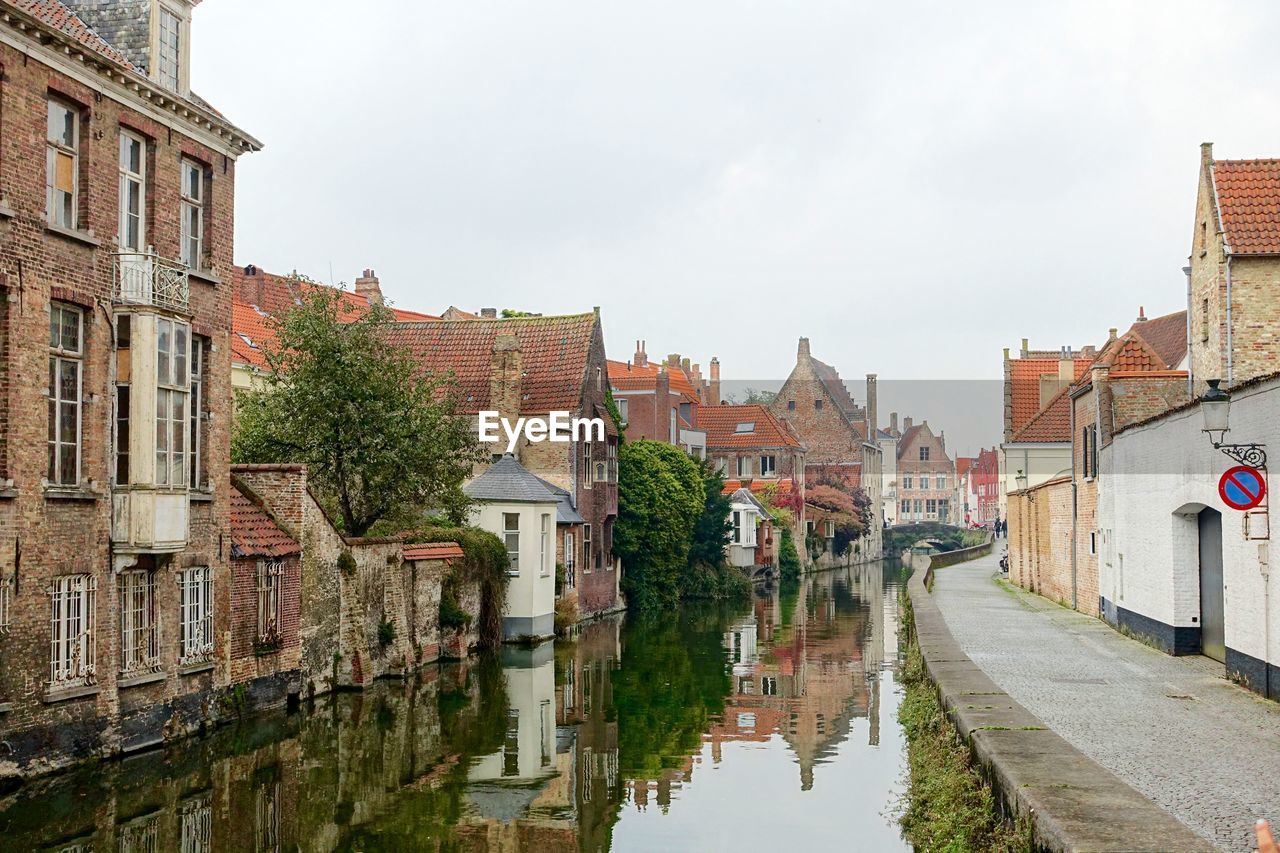 Canal amidst buildings against clear sky