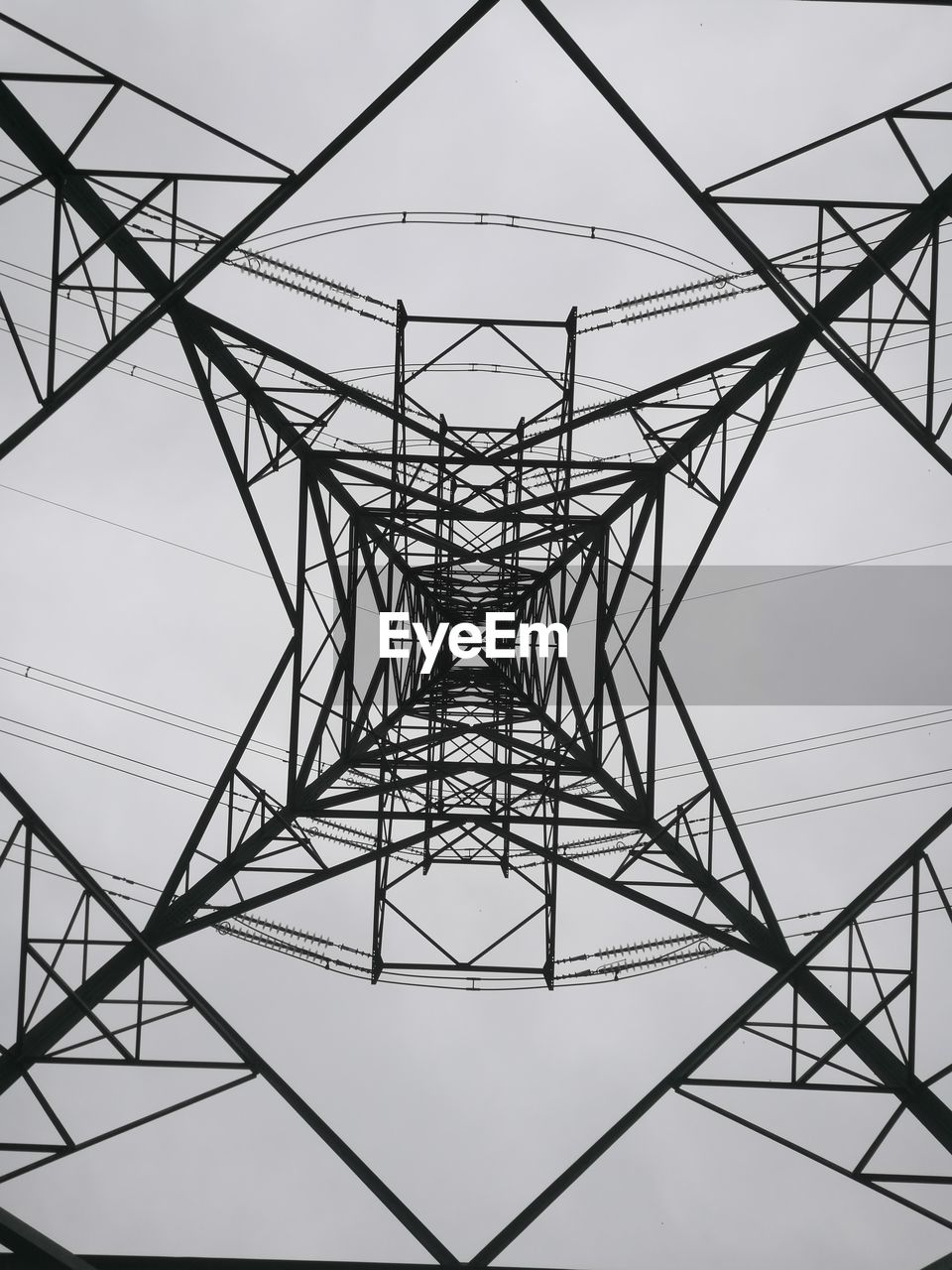 Directly below shot of electricity pylon against sky