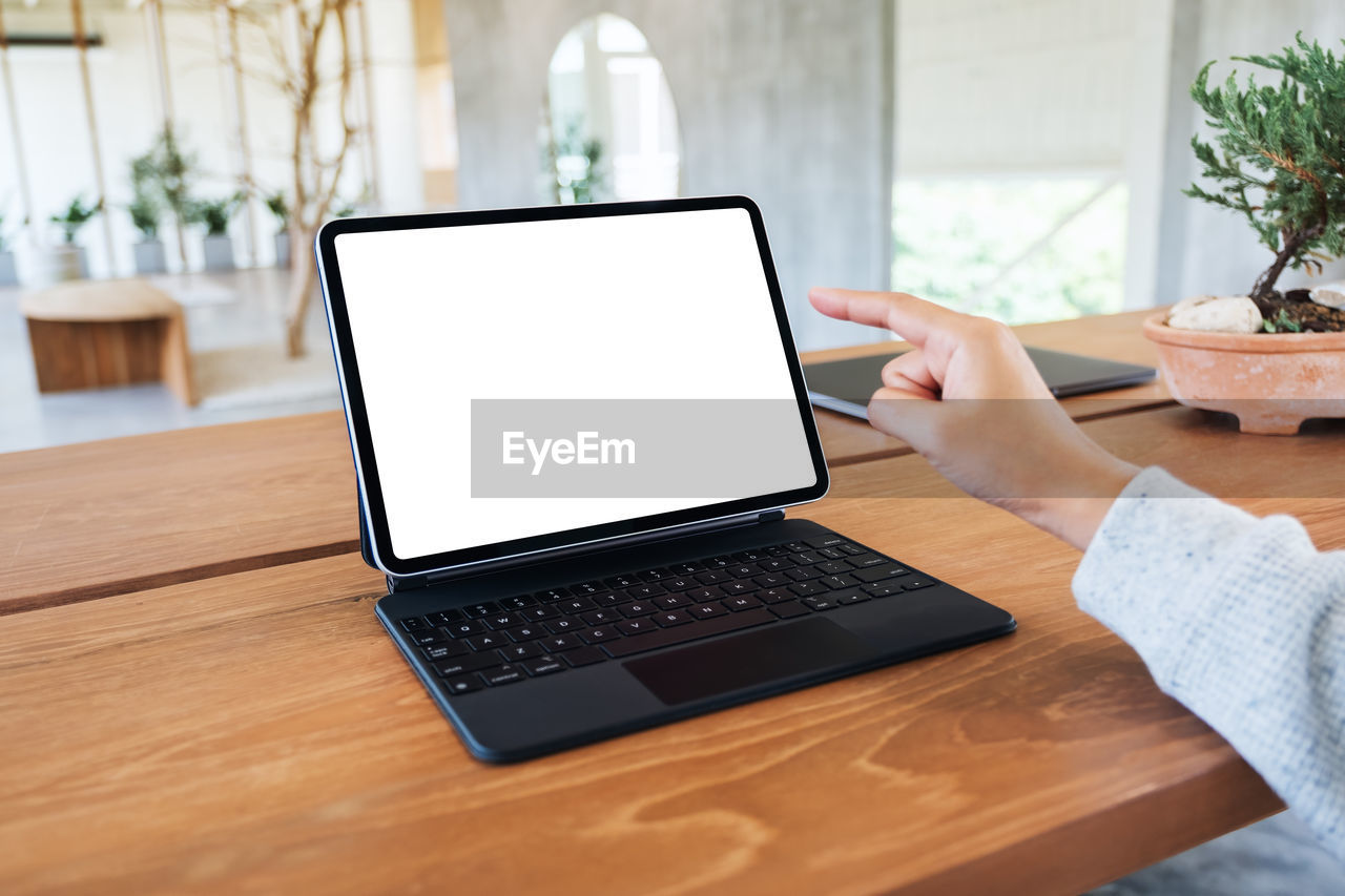 midsection of woman using laptop on table