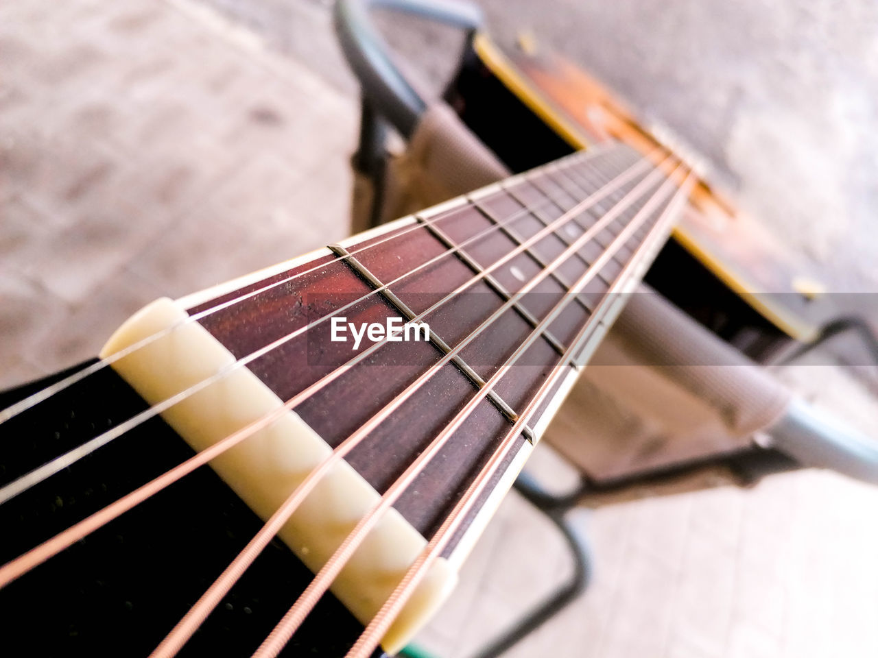 HIGH ANGLE VIEW OF GUITAR ON TABLE AT HOME