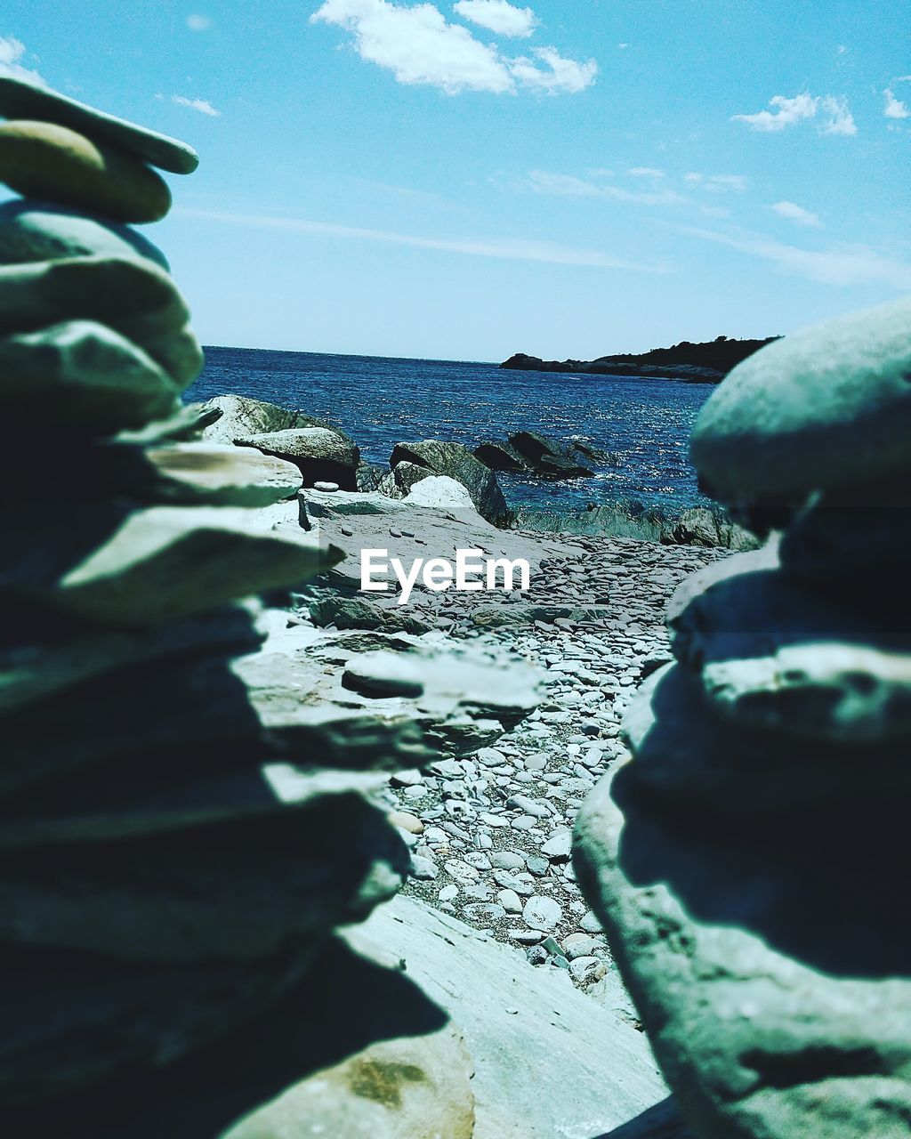 CLOSE-UP OF ROCKS ON SHORE AGAINST SKY