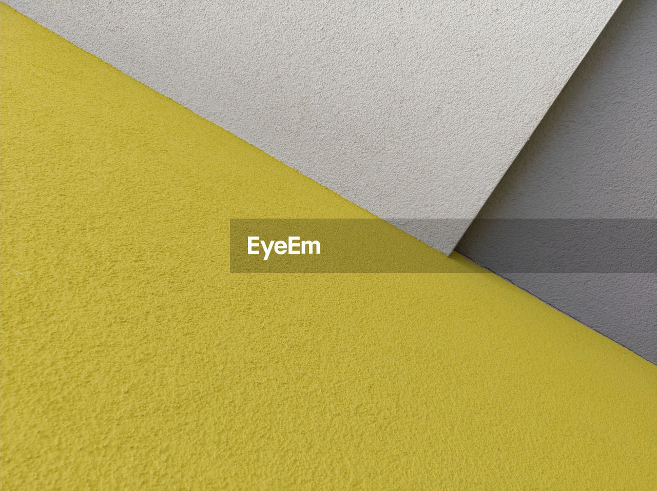 FULL FRAME SHOT OF YELLOW WALL AND PAPER