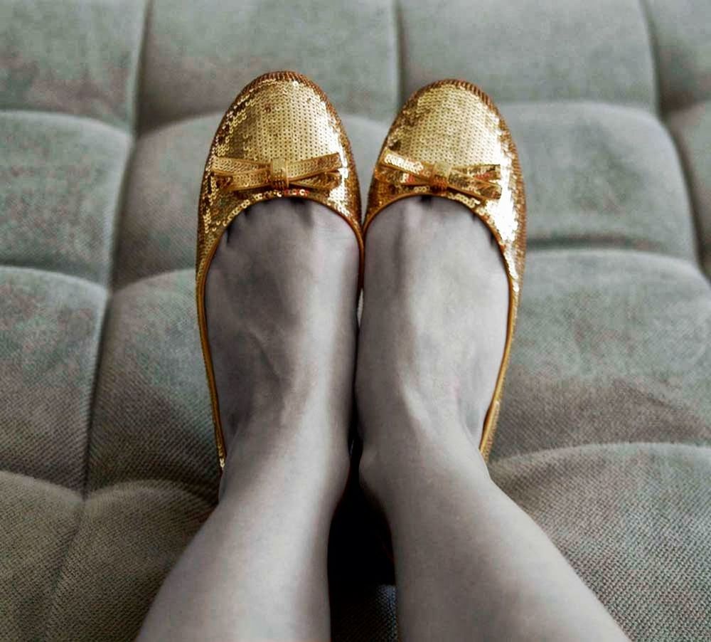 Close-up low section of woman wearing golden shoes