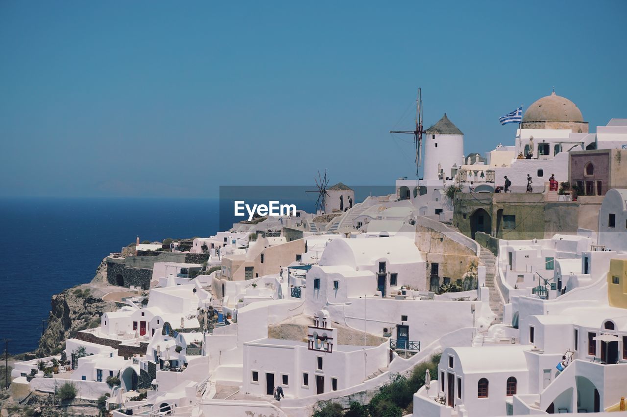 Panoramic view of buildings in oia against blue sky