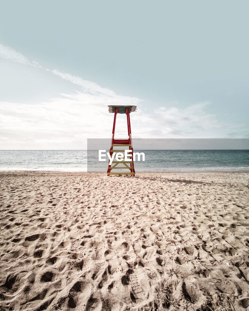 Lifeguard chair on beach against sky