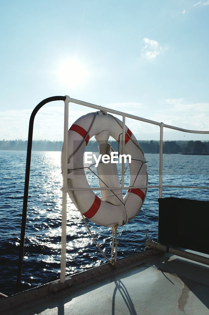 Life belt tied on boat in sea against sky