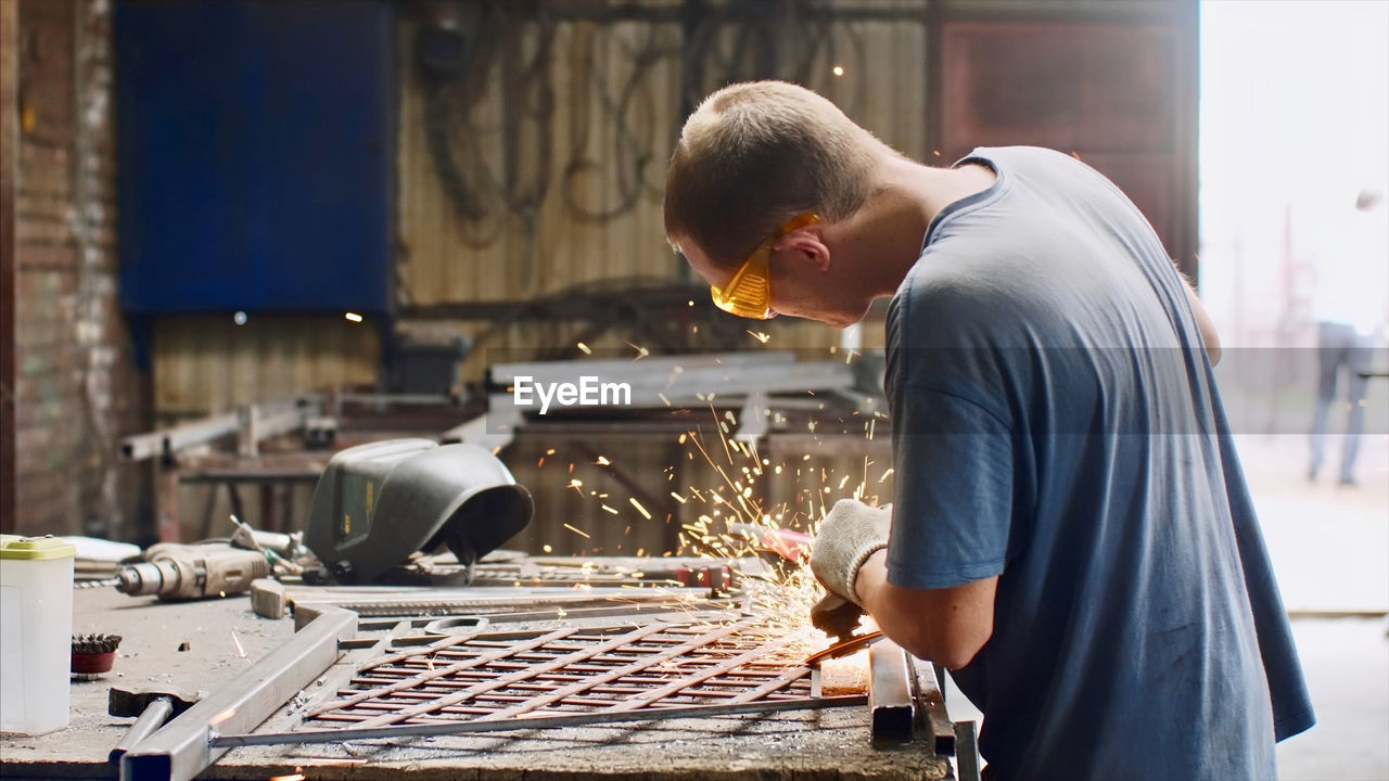 Side view of man welding in workshop