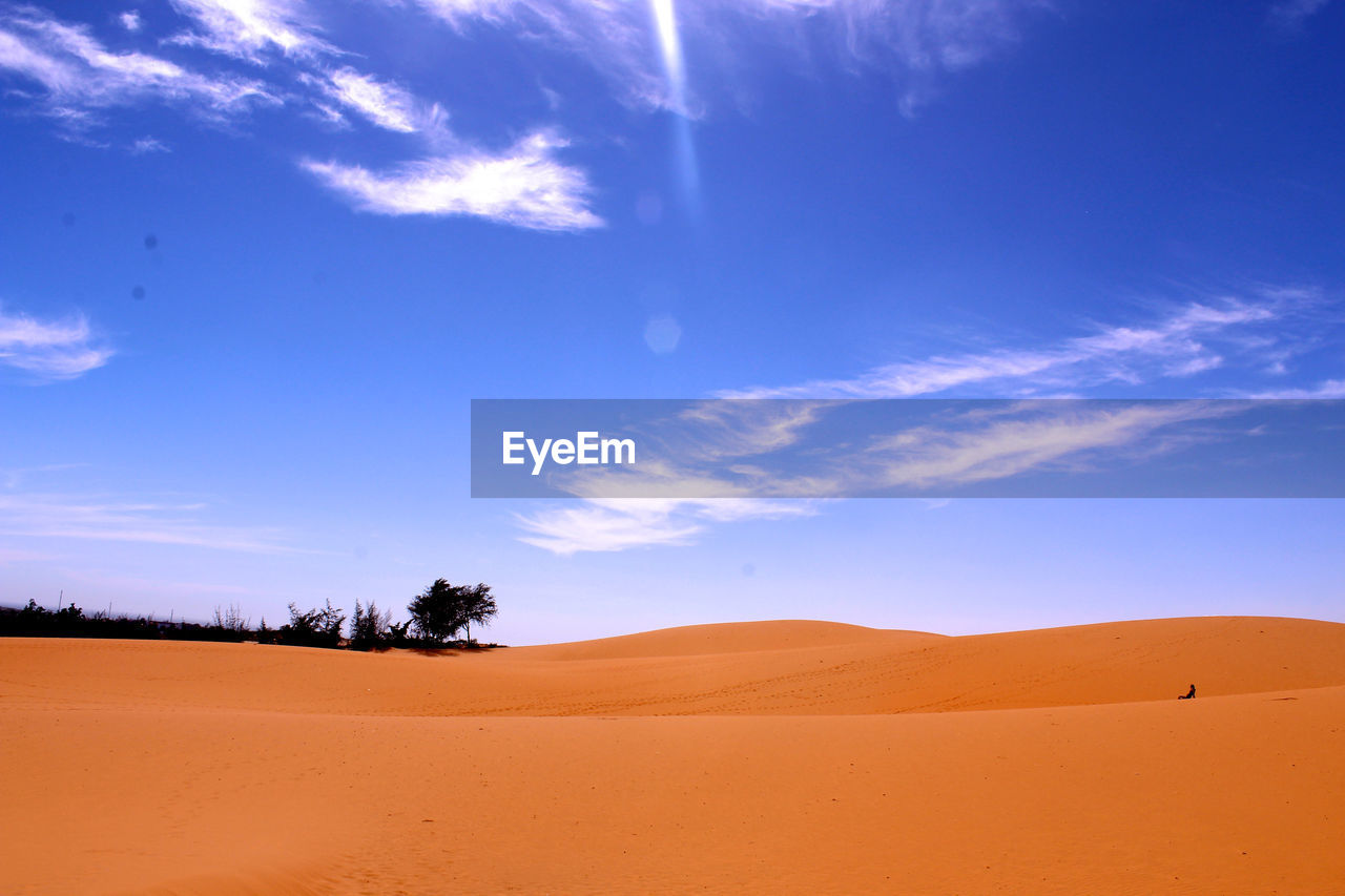 Scenic view of sand dunes against sky