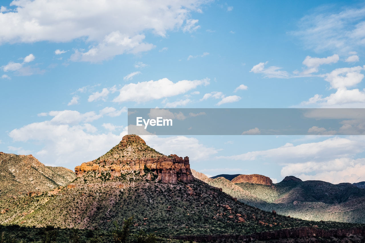 Rock formations on landscape against cloudy sky