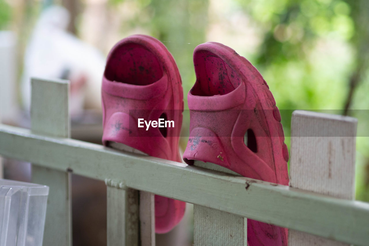 CLOSE-UP OF SHOES ON RAILING