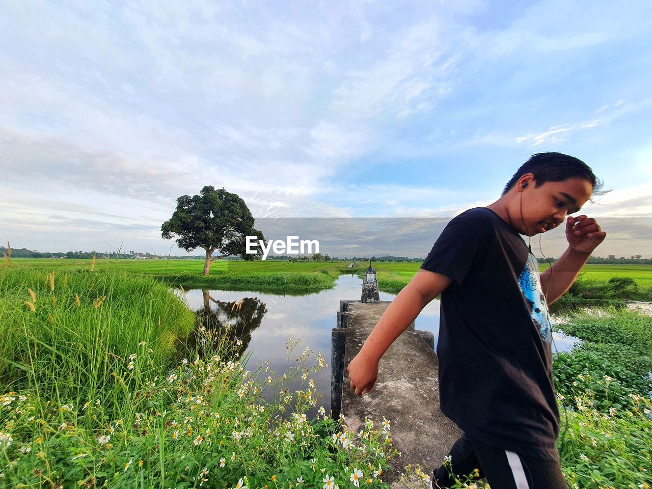 plant, one person, nature, sky, grass, land, adult, water, agriculture, men, landscape, field, environment, cloud, leisure activity, green, lifestyles, meadow, rural area, rural scene, day, outdoors, casual clothing, beauty in nature, three quarter length, growth, food and drink, side view, scenics - nature, standing, activity, looking, occupation, food, young adult, child, person, farm, summer, childhood