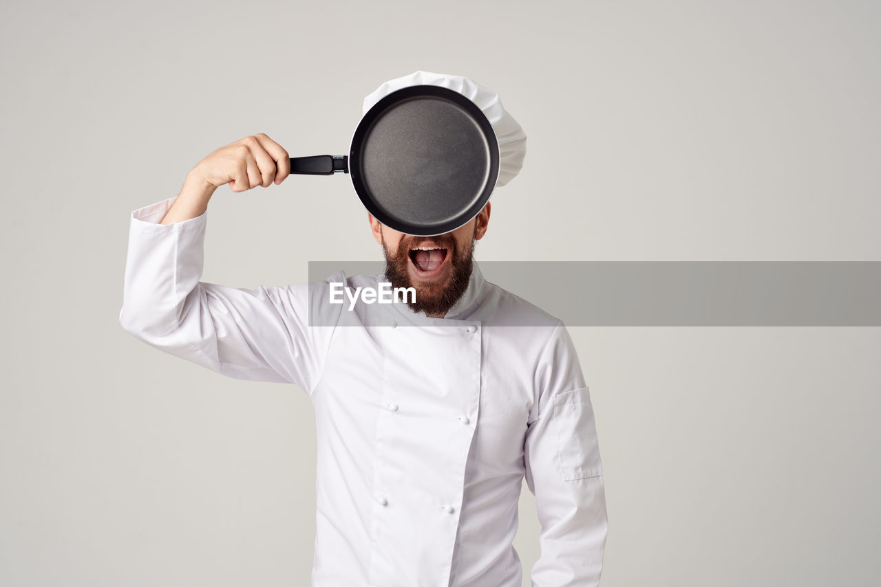 Chef standing against white background