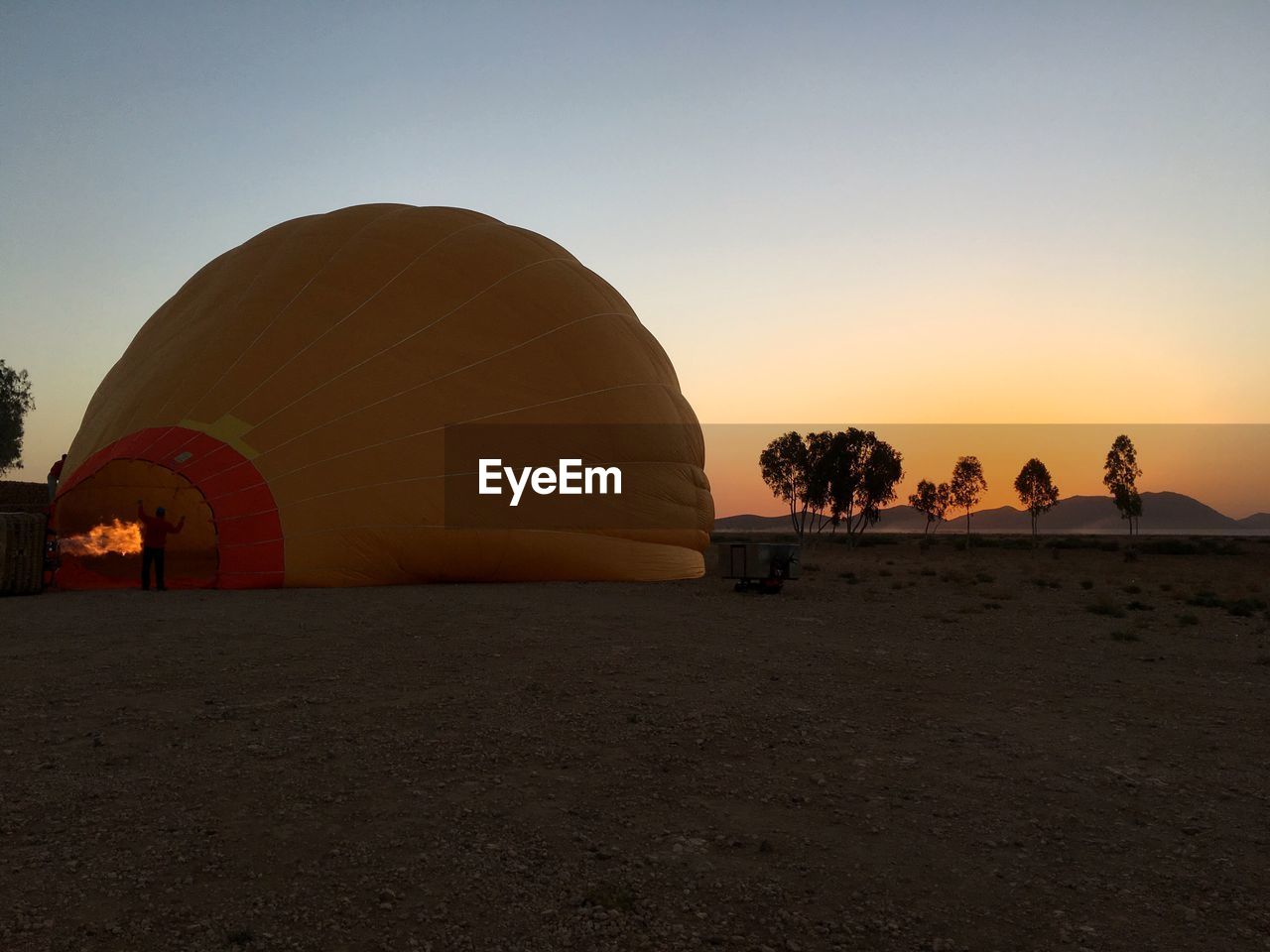 clear sky, sunset, copy space, outdoors, travel destinations, landscape, nature, sky, built structure, desert, beauty in nature, architecture, scenics, vacations, day, building exterior, hot air balloon, tree, no people