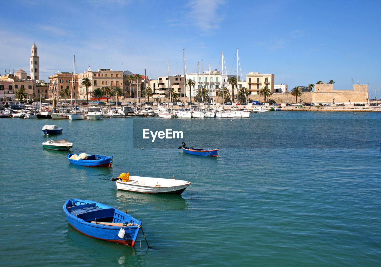 Boats moored on sea against blue sky